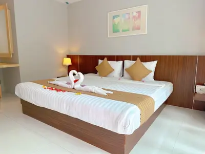 a bedroom with a large bed with two swans on it at Ahad Suite Aonang in Ao Nang Beach