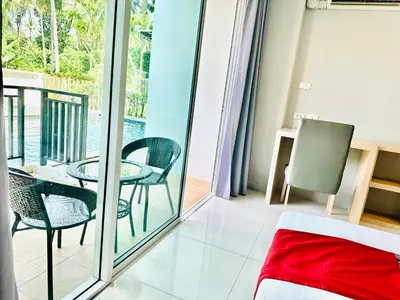 a room with a balcony with a table and chairs at Ahad Suite Aonang in Ao Nang Beach