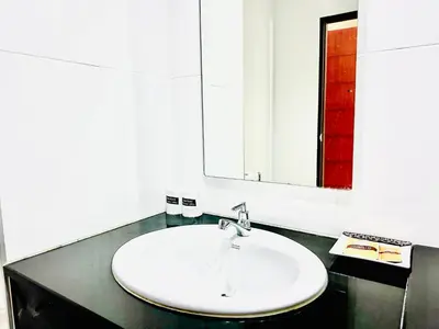 a bathroom with a white sink and a mirror at Ahad Suite Aonang in Ao Nang Beach