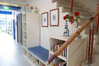 a room with a staircase with a book shelf at The Blue Pearl Kata Hotel in Kata Beach
