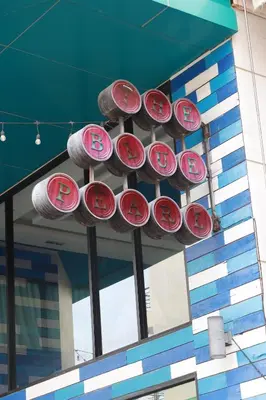 a bunch of red and white signs hanging from a building at The Blue Pearl Kata Hotel in Kata Beach