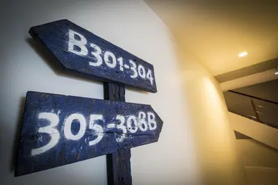 two blue street signs sitting next to a building at The Blue Pearl Kata Hotel in Kata Beach