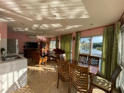 a living room with a table and chairs and a kitchen at Cozy Home With Lake View at Kathu PHUKET 3 BR in Ban Huai Luk (1)