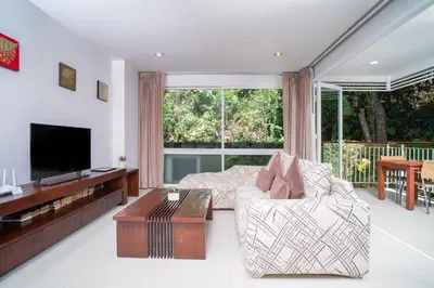 a living room with a couch and a tv at Surin Park by Destada in Surin Beach