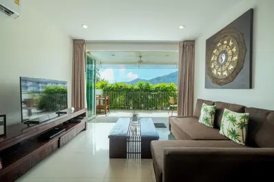 a living room with a couch and a table at Surin Park by Destada in Surin Beach