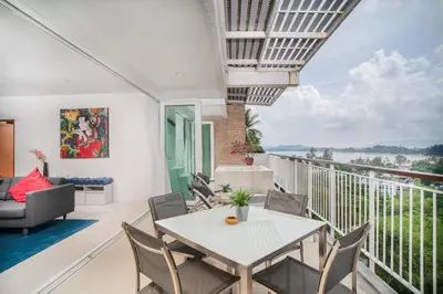a room with a balcony with a table and chairs at Surin Park by Destada in Surin Beach