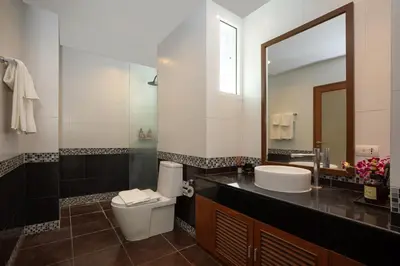 a bathroom with a toilet and a sink and a mirror at Surin Park by Destada in Surin Beach