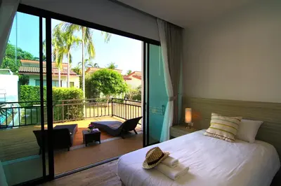 a bedroom with a large bed and a balcony at The Fusion Resort Hotel in Chalong