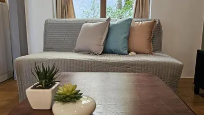 a living room with a couch with pillows and a table at The Fusion Resort Hotel in Chalong