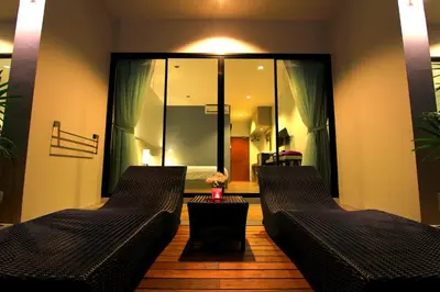 two black leather couches in a room with a bedroom at The Fusion Resort Hotel in Chalong