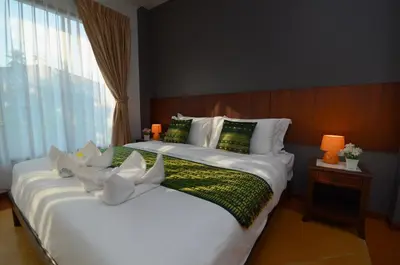 a hotel room with two beds and a window at The Fusion Resort Hotel in Chalong