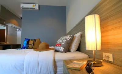 a bedroom with a bed and a table with a lamp at The Fusion Resort Hotel in Chalong