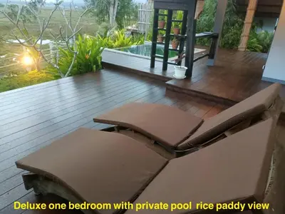 a wooden deck with a bench and a pool at Rongna Villas in Ko Yao Noi