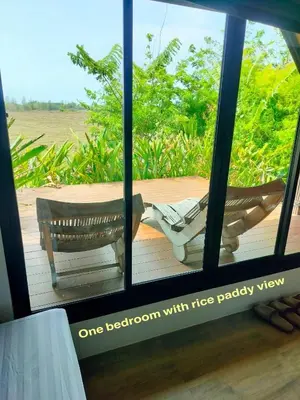 a room with a view of a deck with two chairs at Rongna Villas in Ko Yao Noi