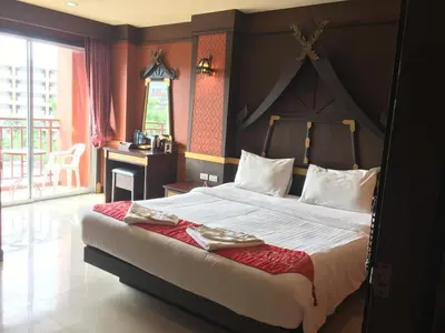 a bedroom with a large bed with a red blanket at 99 Residence in Patong Beach