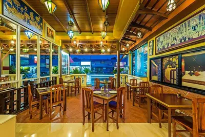 a restaurant with tables and chairs in a room at 99 Residence in Patong Beach