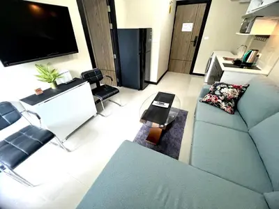 a living room with a couch and a flat screen tv at Apartments MBC 1308 in Mai Khao Beach
