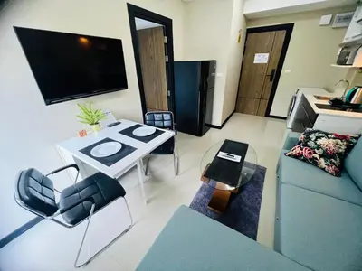 a small living room with a couch and a tv at Apartments MBC 1308 in Mai Khao Beach