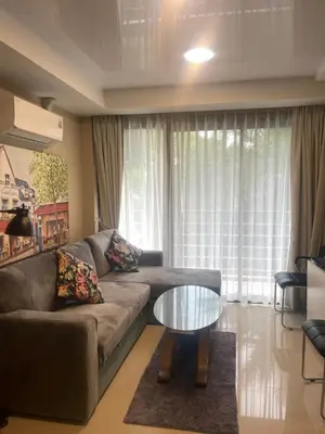 a living room with a couch and a glass table at Apartments MBC 1308 in Mai Khao Beach