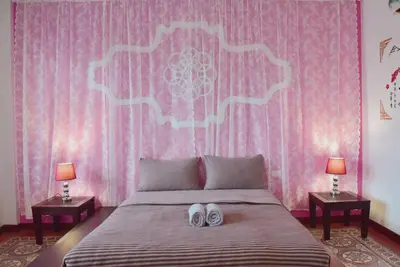 a bedroom with a bed with two white shoes on it at Botan Boutique Hotel in Patong Beach