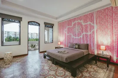 a bedroom with a bed and pink wallpaper at Botan Boutique Hotel in Patong Beach