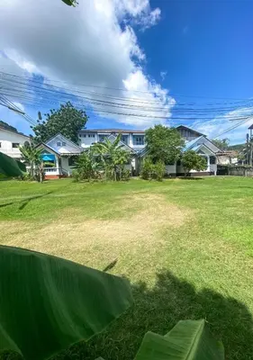 a view of a yard with houses in the background at Karon House 15C in Karon Beach