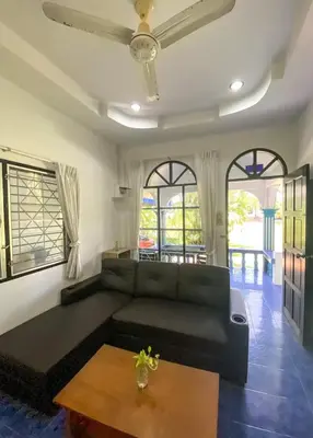 a living room with a black couch and a table at Karon House 15C in Karon Beach