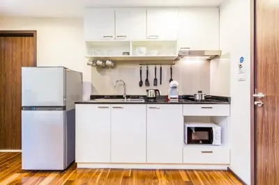 a kitchen with white cabinets and a refrigerator at Direct pool access 2br apartment @The Title Rawai in Rawai Beach