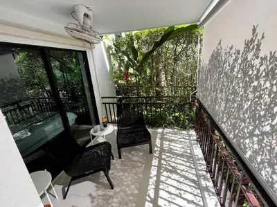 a balcony with two chairs and a window at Direct pool access 2br apartment @The Title Rawai in Rawai Beach