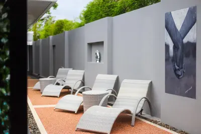 a row of white chairs sitting next to a wall at 3 Bedroom Platinum Pool Villa Smooth as Silk in Ban Khlong Haeng