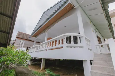 a white house with a staircase in front at Kataonsea bungalows in Kata Beach