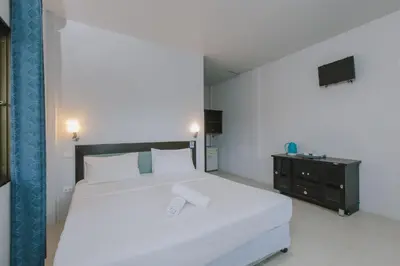 a bedroom with a large white bed and a dresser at Kataonsea bungalows in Kata Beach