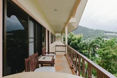 a balcony with chairs and a view of the mountains at Kataonsea bungalows in Kata Beach
