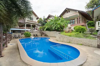 a large blue swimming pool in front of a house at Kataonsea bungalows in Kata Beach