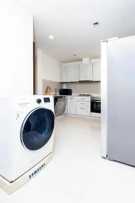 a kitchen with a washing machine in a white kitchen at Laguna Park Modern Pool Villa in Phuket Town