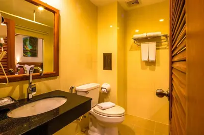 a bathroom with a toilet and a sink and a mirror at Patong Heaven in Patong Beach