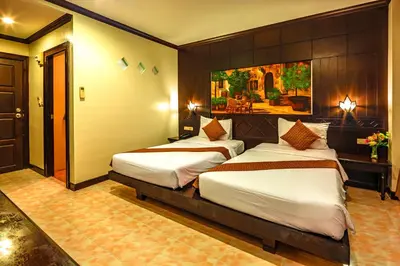 a bedroom with two beds and a painting on the wall at Patong Heaven in Patong Beach