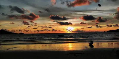 a person flying a kite on the beach at sunset at Sawansa 34A Modern Luxury 3BR Sea View 450m2 in Patong Beach