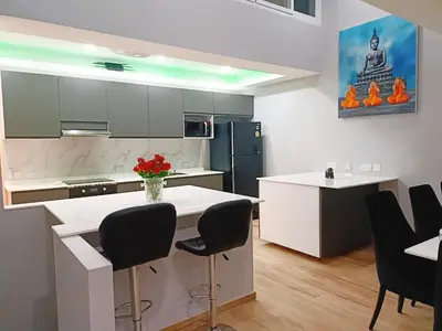 a kitchen with a white counter and black chairs at Sawansa 34A Modern Luxury 3BR Sea View 450m2 in Patong Beach