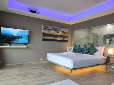 a bedroom with a bed and a tv on the wall at Sawansa 34A Modern Luxury 3BR Sea View 450m2 in Patong Beach