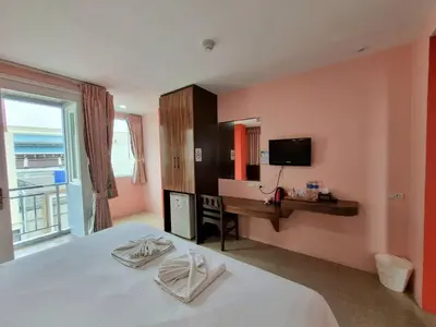 a bedroom with a bed and a desk and a television at 77 Patong Hotel & Spa in Patong Beach