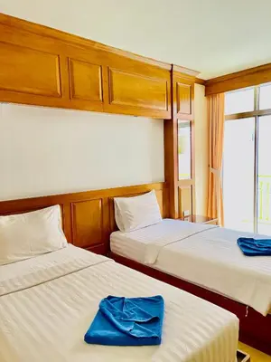 a bedroom with two beds with blue towels on them at Innarm House Patong in Patong Beach