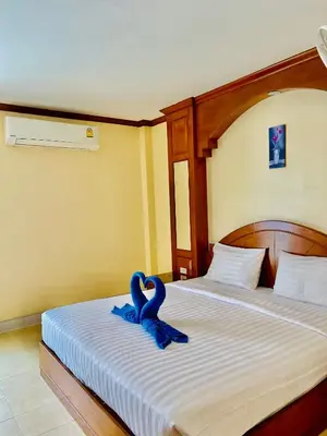 a bedroom with a bed with blue ribbon on it at Innarm House Patong in Patong Beach
