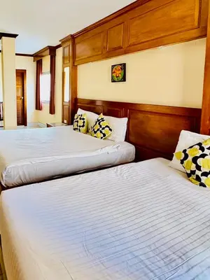 two beds in a hotel room with at Innarm House Patong in Patong Beach