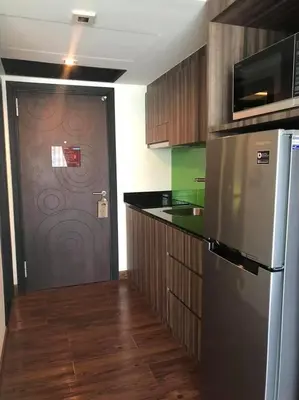 a kitchen with a refrigerator and a door with a microwave at The Beach by Glitter House in Kata Beach