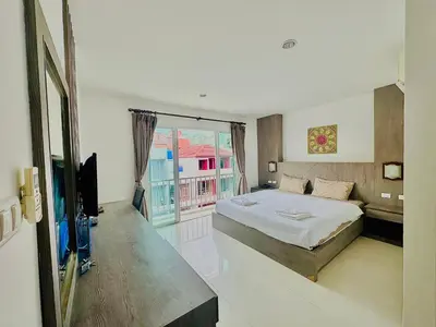 a bedroom with a large bed and a balcony at Cocoon Patong Hotel in Patong Beach