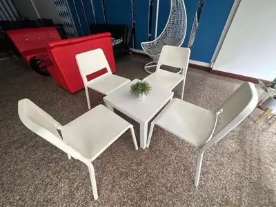 four white chairs and a table and a red couch at Cocoon Patong Hotel in Patong Beach