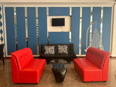 a living room with two chairs and a tv at Cocoon Patong Hotel in Patong Beach