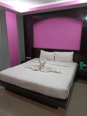 a bedroom with a bed with a purple headboard at Lavender Patong Hotel in Patong Beach