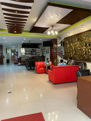 two people sitting on red couches in a lobby at Lavender Patong Hotel in Patong Beach